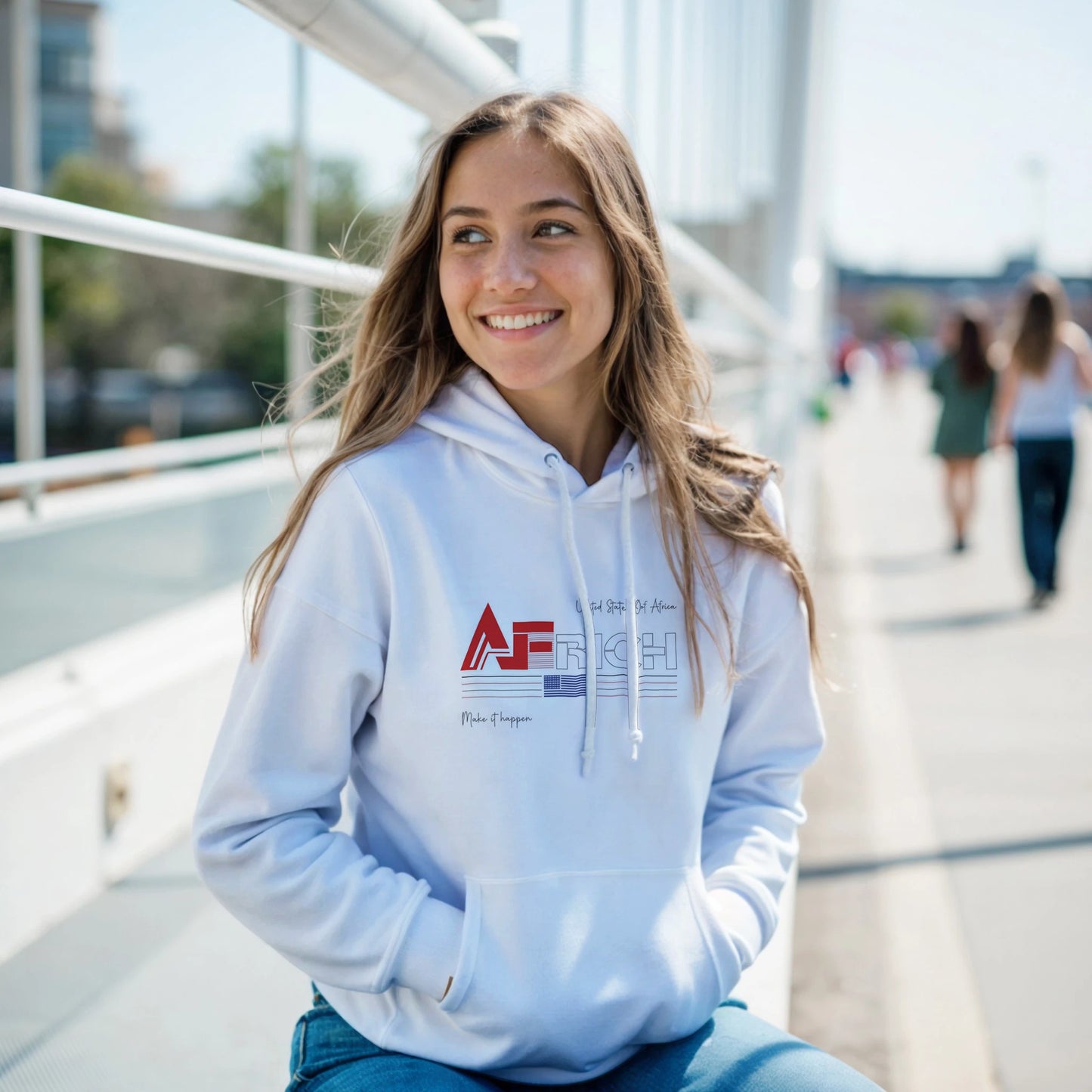 AFRICH® Adult Timeless Style Classic Unisex Pullover white Hoodie. Man wearing a white hoodie with a logo and text, standing on a bridge with a cityscape background.